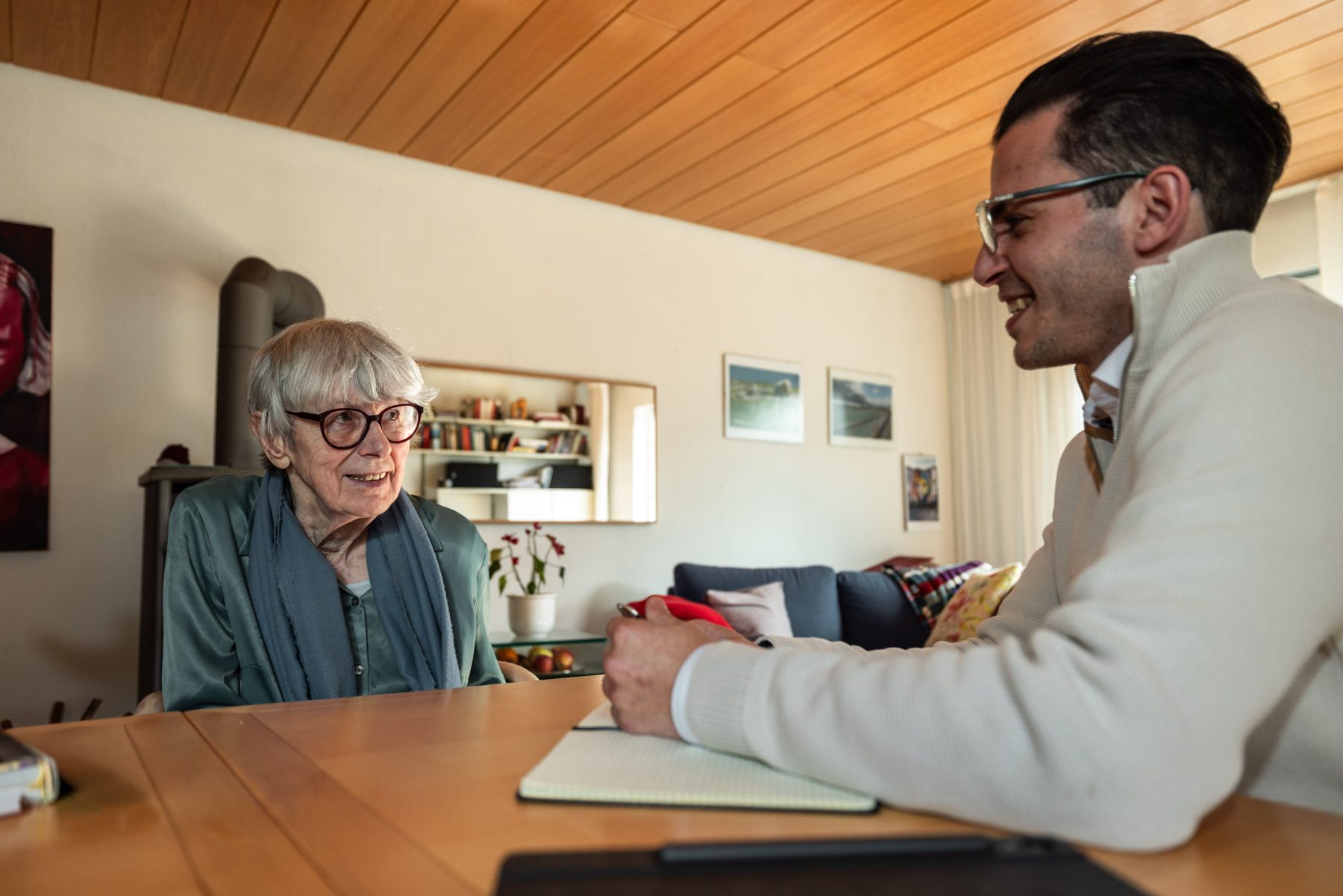 Dominik Gissler von Nah & Da im Gespräch mit einer Seniorin an ihrem Esstisch